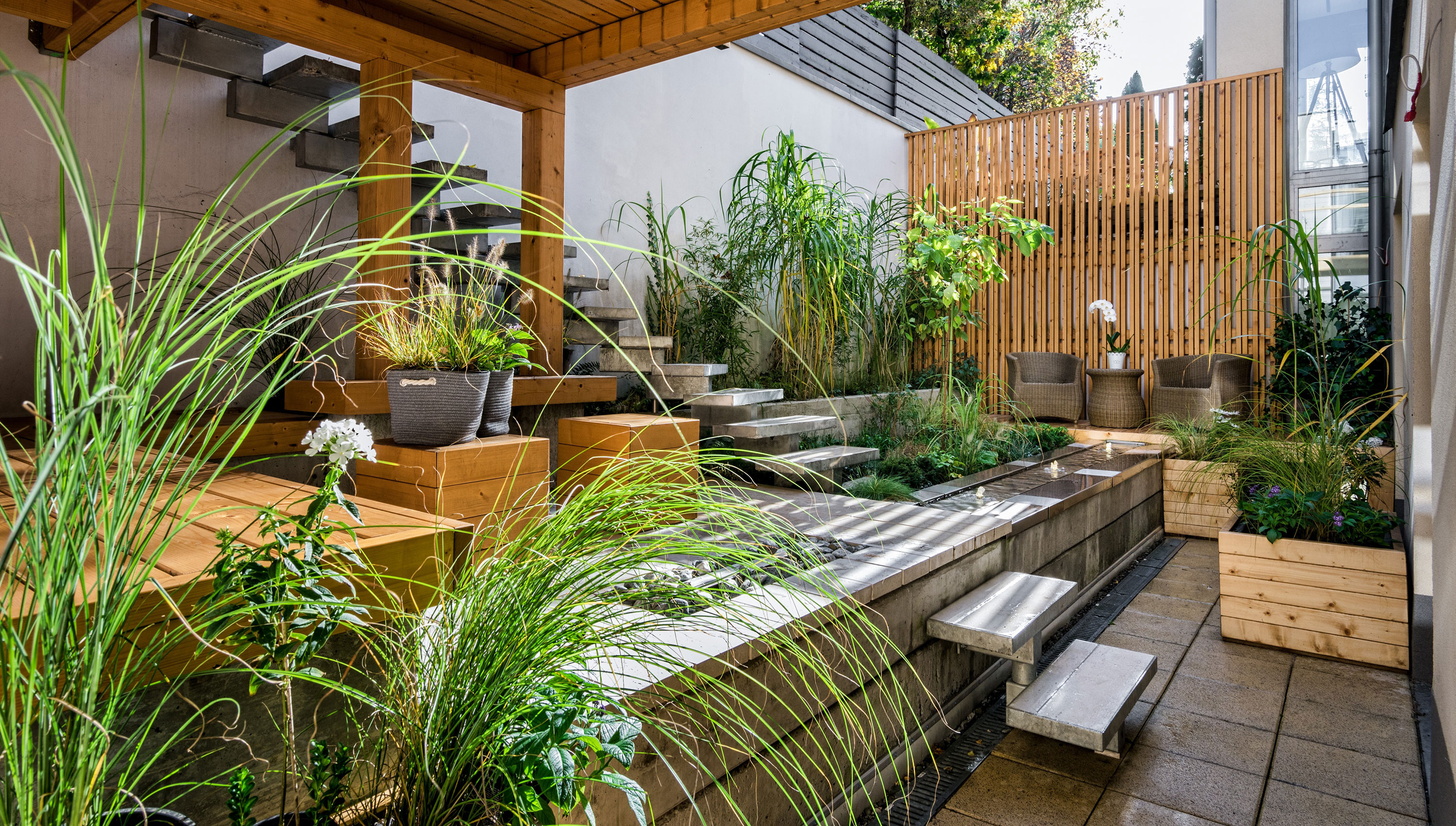 Flora Gartenbau - Foto einer grünen Innenhofgestaltung mit Sitzplätzen