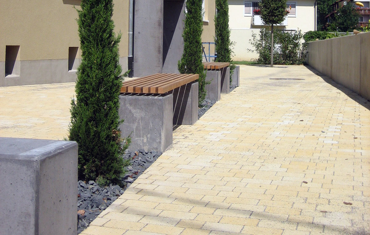 Foto eines geplasterten Gehwegbereichs mit Grünflächen, umgesetzt von Flora Gartenbau, Südbaden